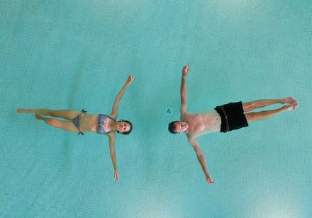 Zwei Personen beim Aquafloating treiben im Wasser